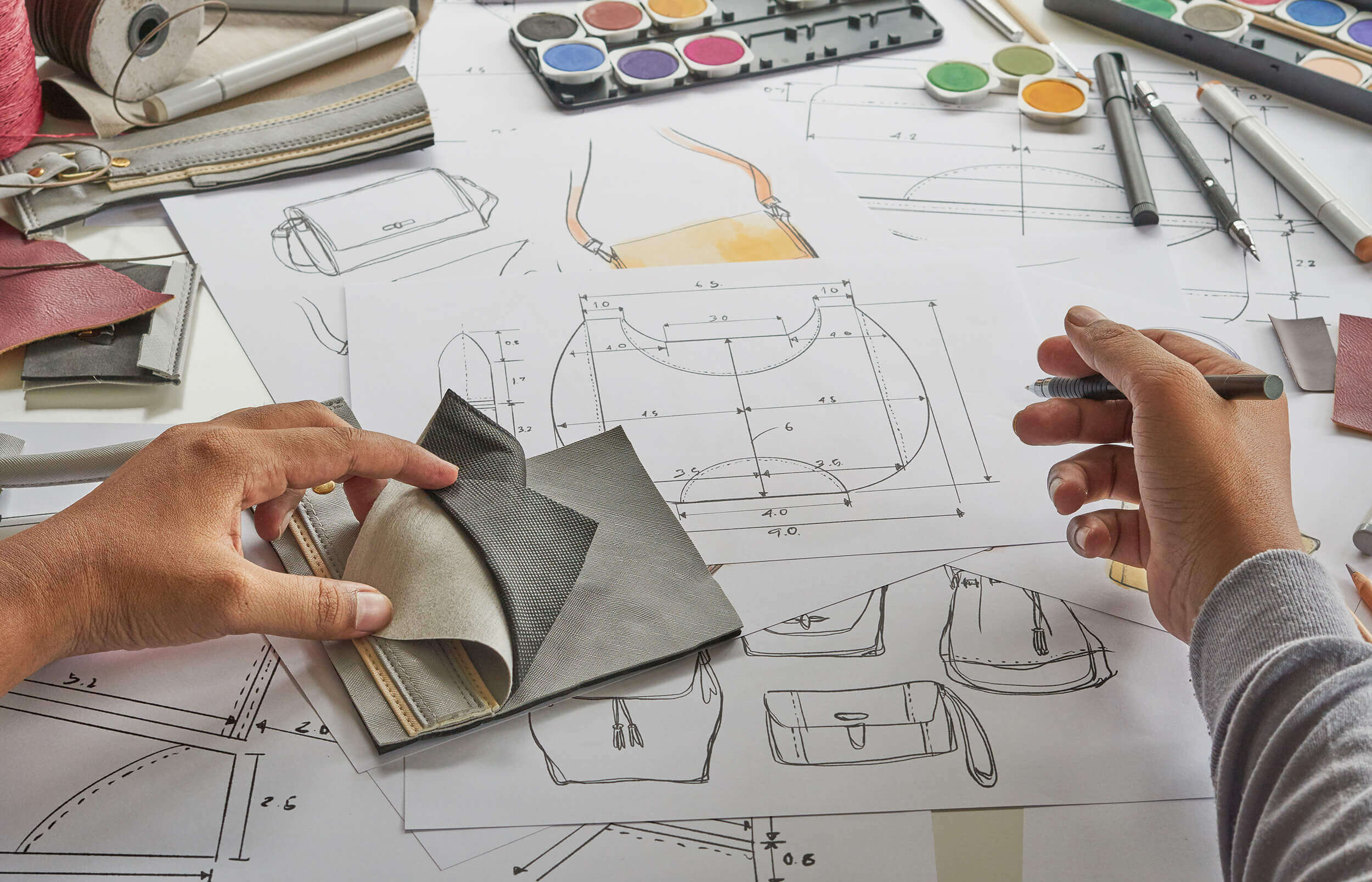 handbag-designer-working-aalofts-design Handbag Designer Sketching Technical Drawings